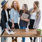 a group of women standing around a wooden table